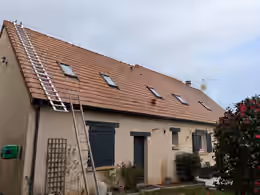 Pavillon à la toiture en tuiles nettoyée, échelles encore en place le long de la façade